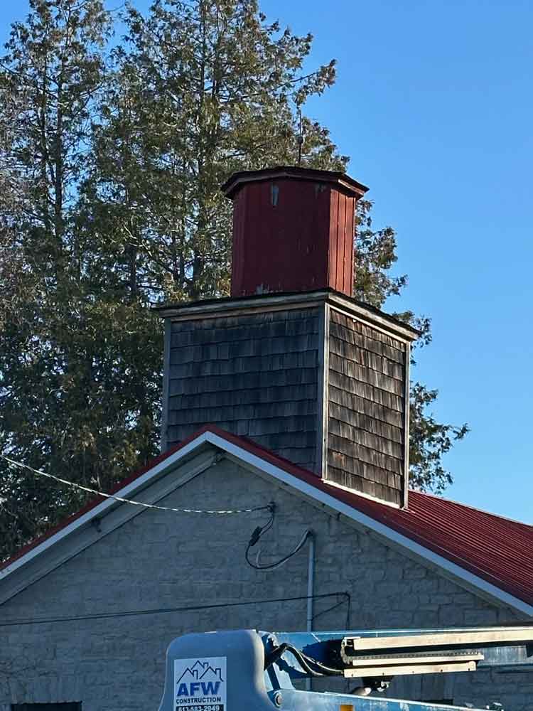 Old schoolhouse bell covered with red wood