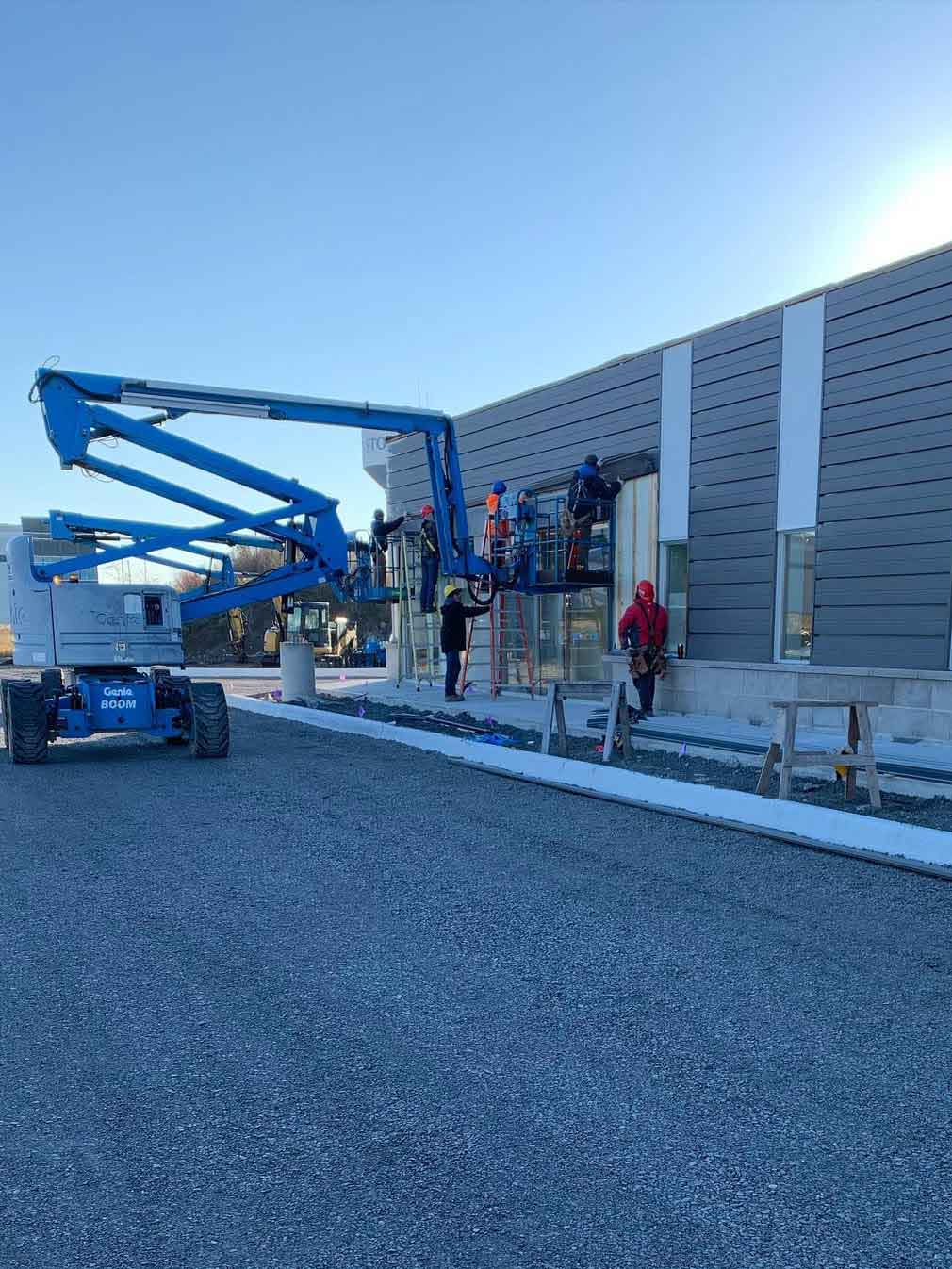 AFW staff installing steel siding on exterior of commercial building