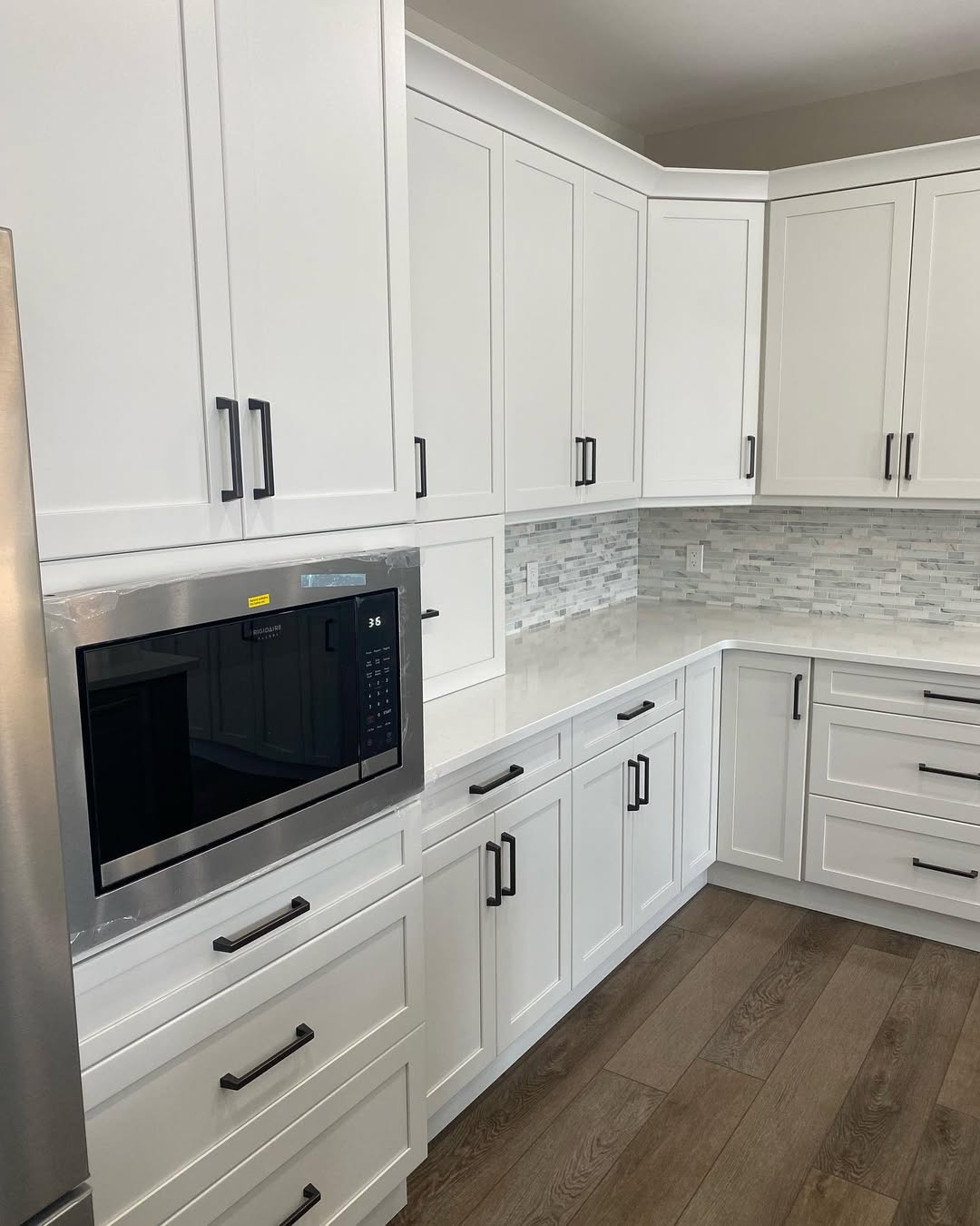 Kitchen cabinets with built in microwave and grey tile backsplash