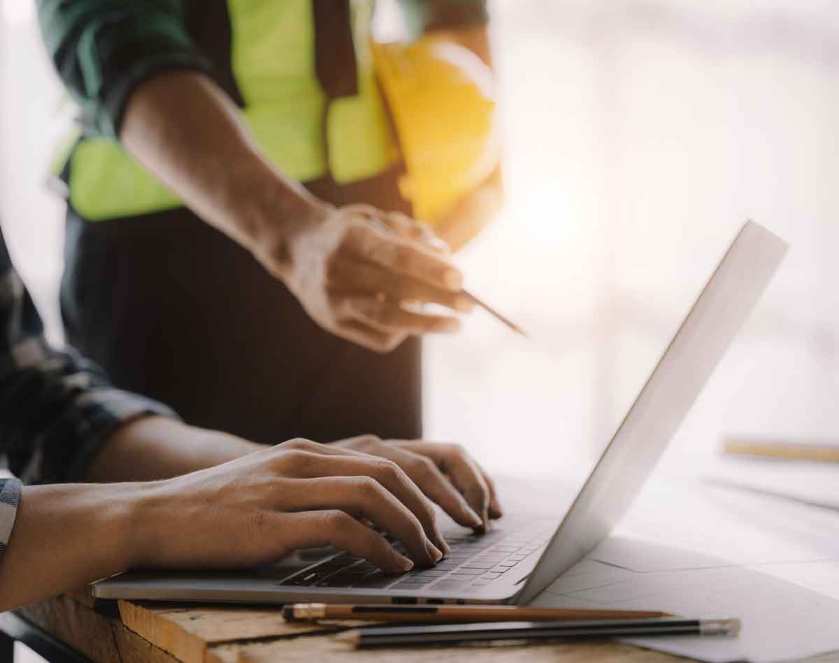 Two men look at commercial tenders submitted on computer